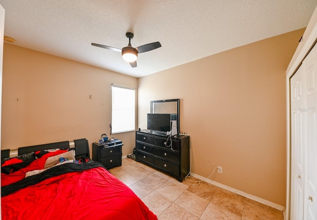 tiled bedroom with a textured ceiling, a closet, and ceiling fan