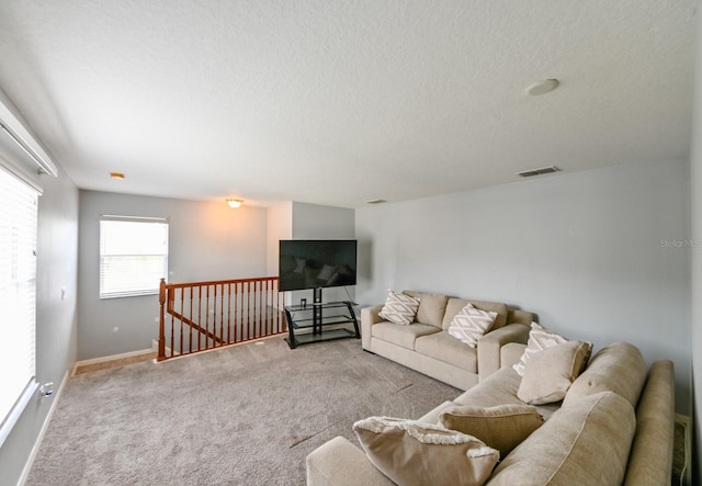 carpeted living room with a textured ceiling