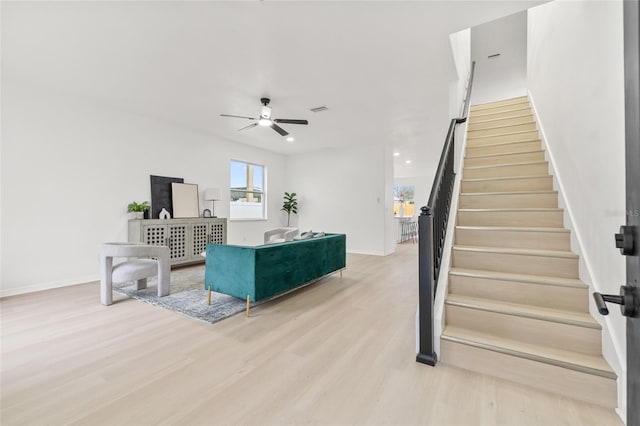 living room featuring ceiling fan and light hardwood / wood-style flooring