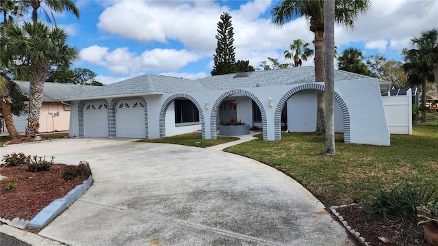 single story home with driveway, stucco siding, an attached garage, and a front yard