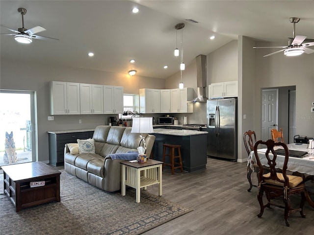 living room featuring ceiling fan, a wealth of natural light, and dark hardwood / wood-style flooring