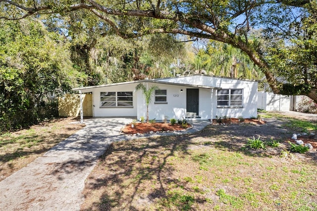 view of front facade with concrete driveway and fence