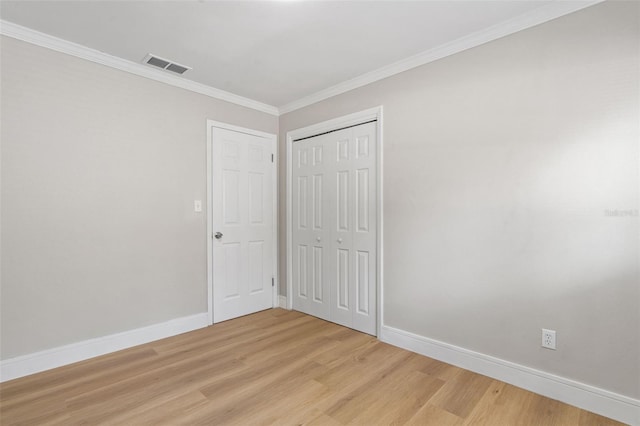 1212 E Crawford St, Tampa, FL 33604 - unfurnished bedroom with light wood-type flooring, baseboards, crown molding, and a closet