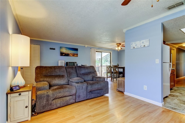 living room with light hardwood / wood-style flooring, ceiling fan, and ornamental molding