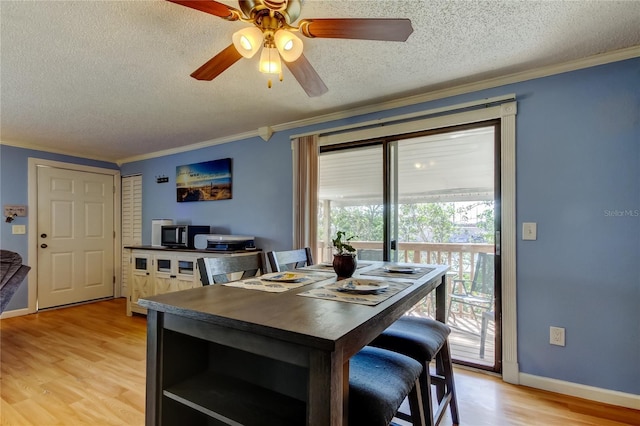 dining space featuring ceiling fan, light hardwood / wood-style flooring, crown molding, and a textured ceiling