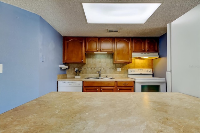 kitchen with white appliances, sink, a textured ceiling, and decorative backsplash