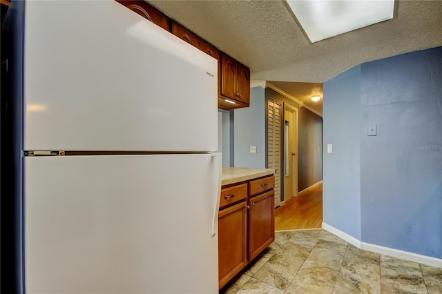 kitchen featuring a textured ceiling and white refrigerator