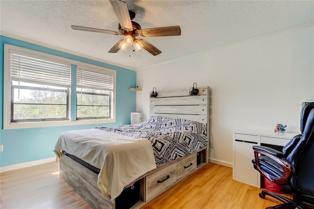 bedroom with light wood-type flooring, crown molding, a textured ceiling, and ceiling fan