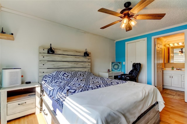 bedroom with ornamental molding, ensuite bathroom, ceiling fan, and light hardwood / wood-style flooring