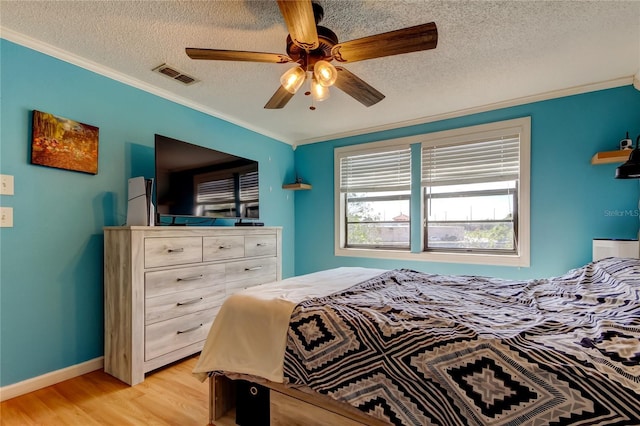 bedroom featuring light hardwood / wood-style floors, crown molding, a textured ceiling, and ceiling fan