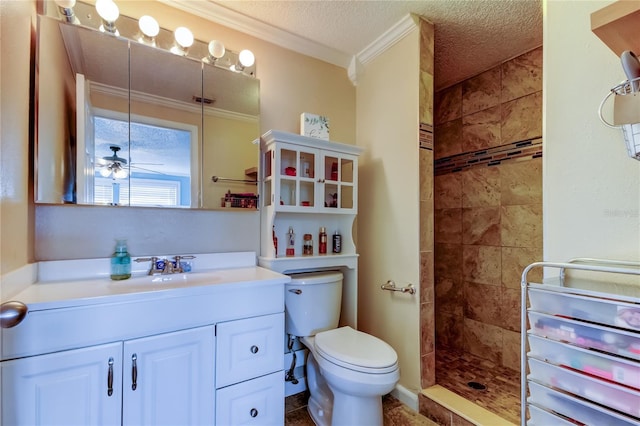 bathroom featuring ornamental molding, toilet, a textured ceiling, vanity, and tiled shower