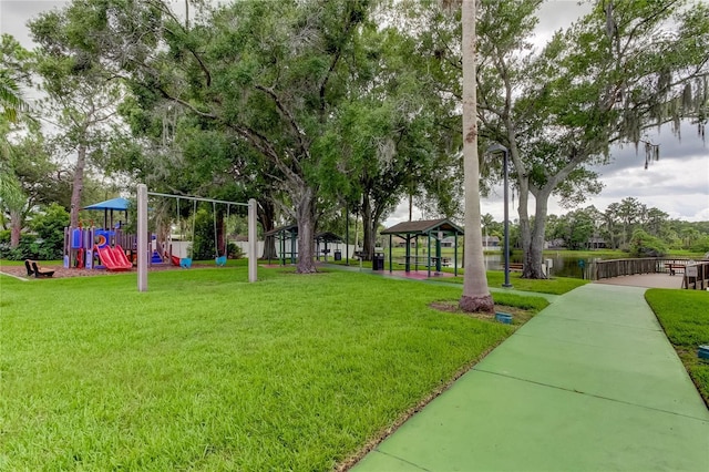 view of home's community featuring a playground, a water view, and a yard