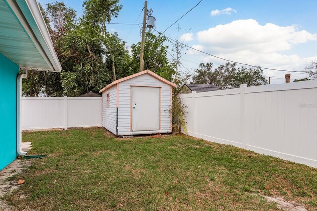 view of yard featuring a fenced backyard, an outdoor structure, and a storage shed