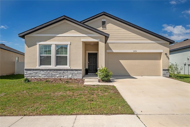 view of front of property featuring stone siding, an attached garage, concrete driveway, and a front lawn