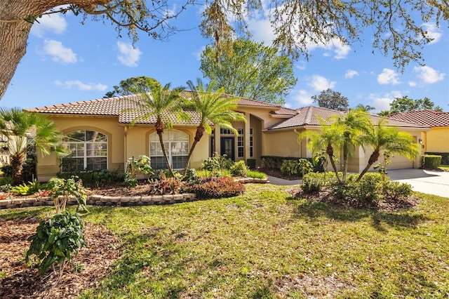 mediterranean / spanish home featuring stucco siding, a tiled roof, concrete driveway, and a garage