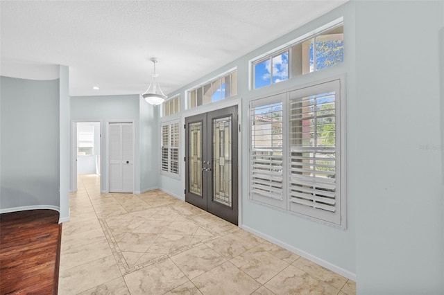 foyer featuring recessed lighting, baseboards, and a textured ceiling