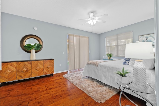 bedroom with baseboards, wood finished floors, and a ceiling fan