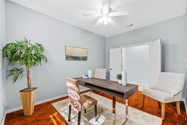 office space with baseboards, wood finished floors, visible vents, and ceiling fan