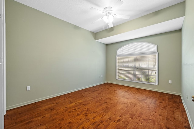 empty room featuring baseboards, ceiling fan, and wood finished floors