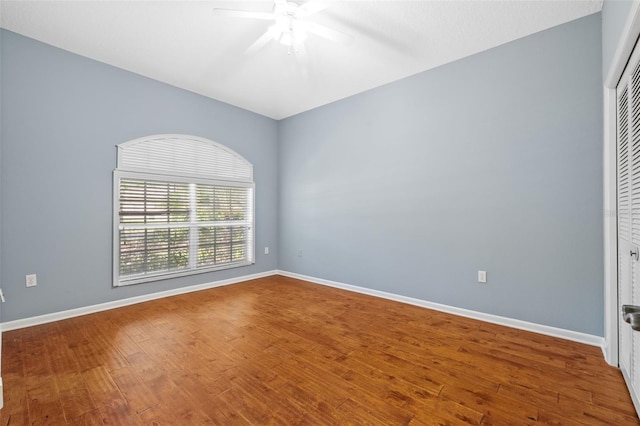 spare room featuring baseboards, ceiling fan, and wood finished floors