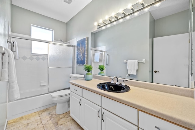 full bath featuring tile patterned flooring, visible vents, toilet, combined bath / shower with glass door, and vanity