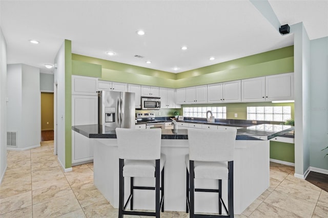 kitchen featuring visible vents, appliances with stainless steel finishes, and white cabinetry