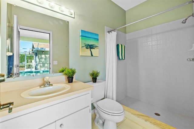 bathroom featuring a tile shower, toilet, and vanity