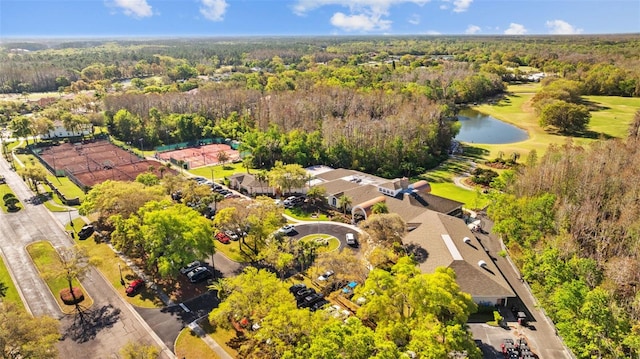 drone / aerial view with a wooded view and a water view