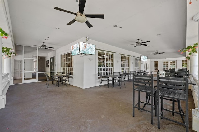 dining area featuring french doors, concrete floors, and a ceiling fan