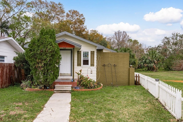 view of front facade with a front lawn and a fenced backyard