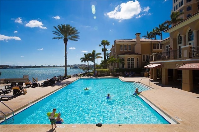 pool with a patio area and a water view