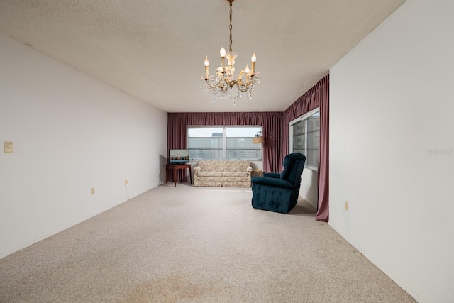 unfurnished room with carpet, a textured ceiling, and a notable chandelier