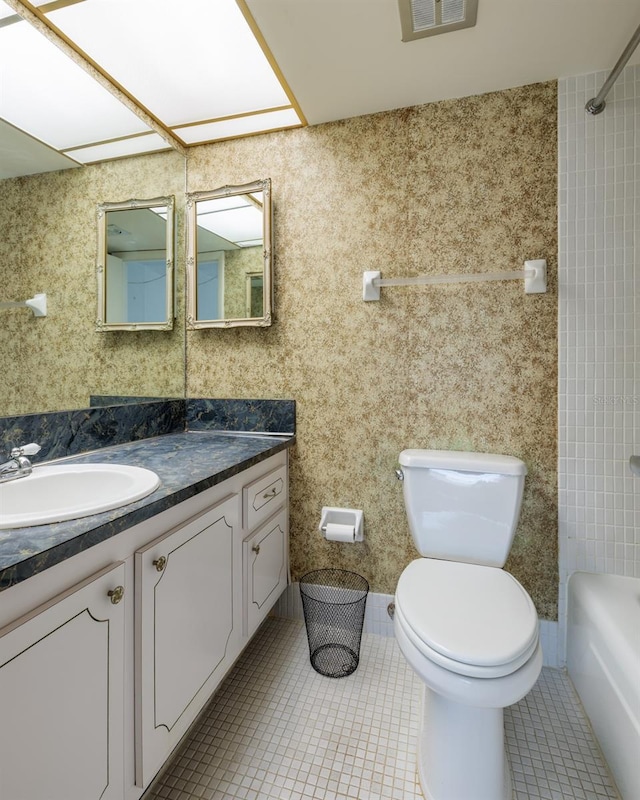 full bathroom with bathing tub / shower combination, toilet, vanity, and tile patterned flooring