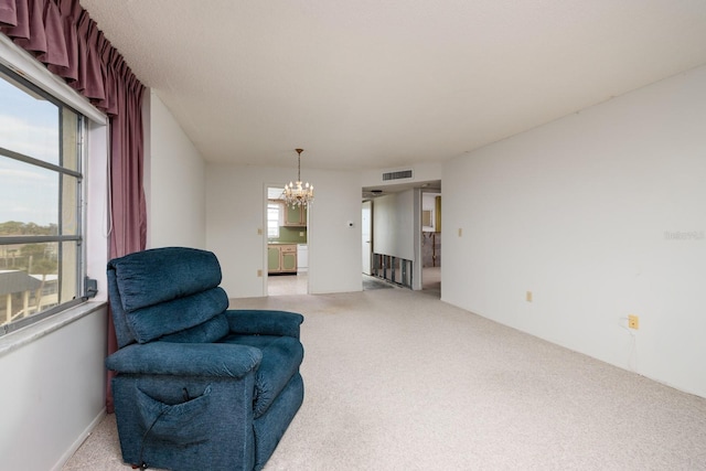 living area with light colored carpet and a notable chandelier