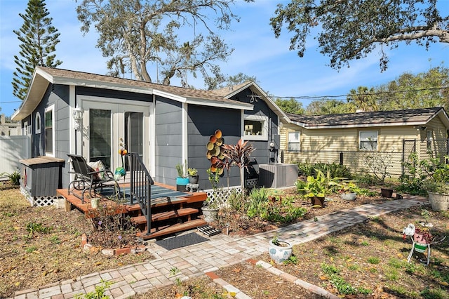 rear view of house featuring a wooden deck, cooling unit, and french doors