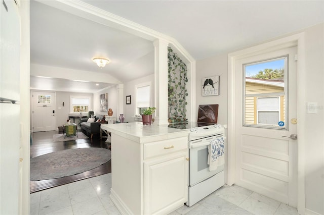 kitchen with electric stove, white cabinets, and a healthy amount of sunlight