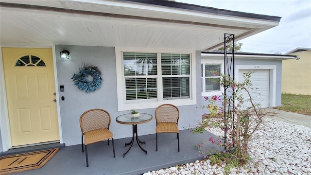 entrance to property featuring an attached garage and stucco siding