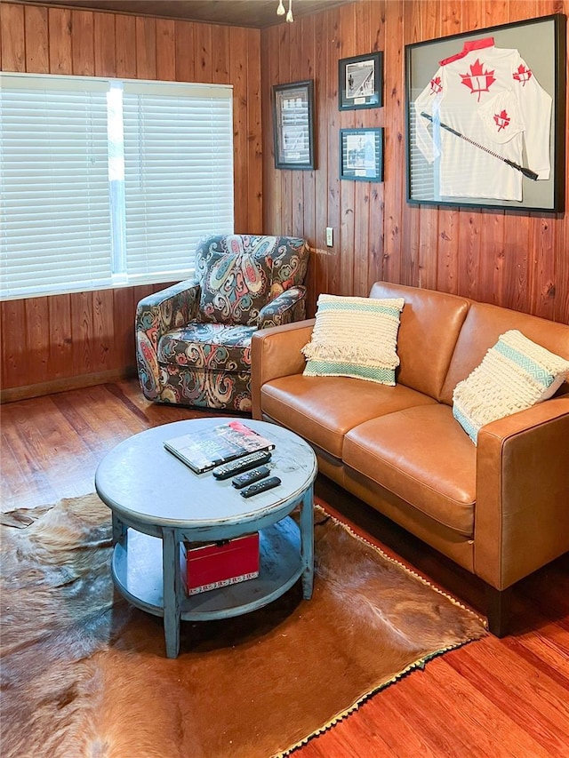 living room with hardwood / wood-style floors and wood walls