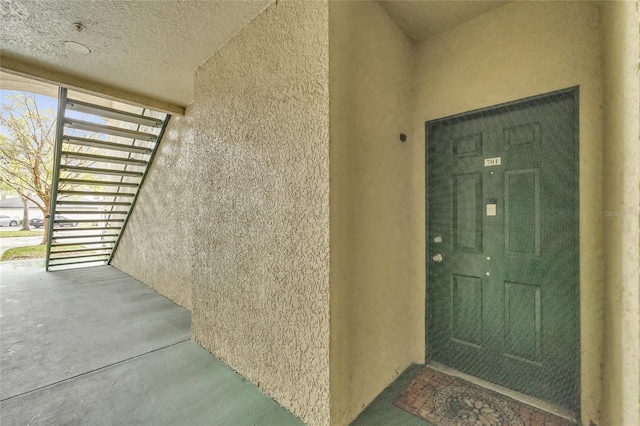 doorway to property featuring stucco siding