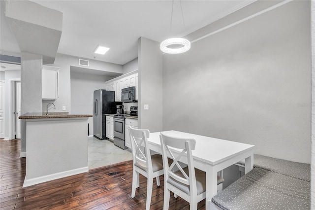 dining area featuring visible vents, baseboards, and wood-type flooring