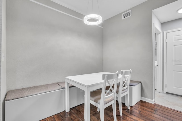 dining space with visible vents, baseboards, and wood finished floors