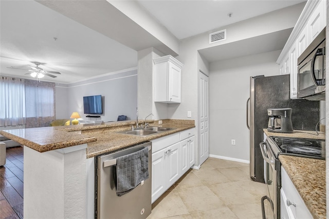 kitchen with visible vents, a peninsula, a sink, white cabinets, and appliances with stainless steel finishes