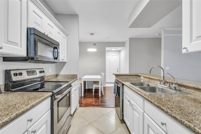 kitchen with visible vents, a sink, white cabinetry, appliances with stainless steel finishes, and light tile patterned flooring