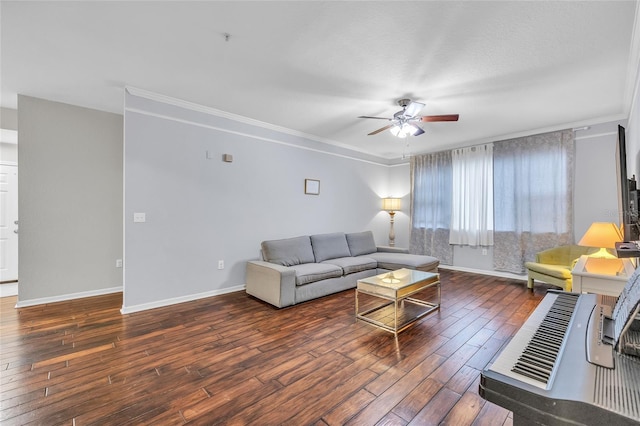 living area featuring baseboards, crown molding, ceiling fan, and wood finished floors