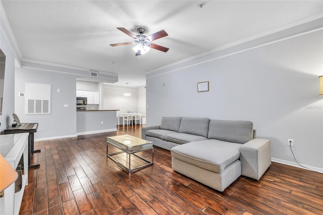 living area featuring ceiling fan, crown molding, dark wood-type flooring, and baseboards