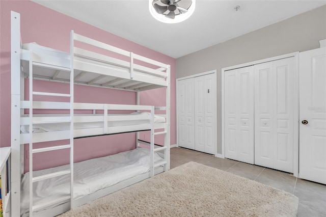 unfurnished bedroom with tile patterned flooring and two closets