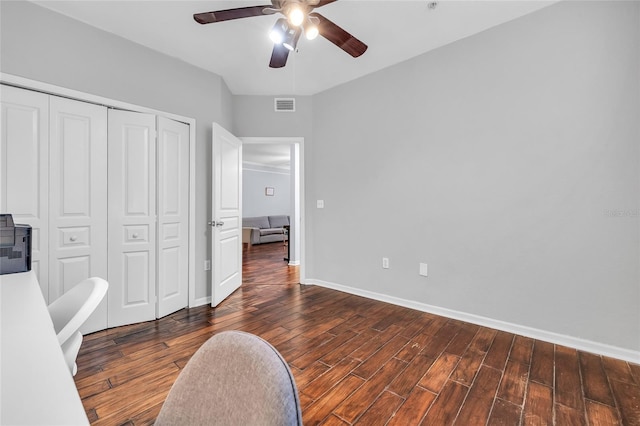 bedroom with wood finished floors, visible vents, baseboards, ceiling fan, and a closet