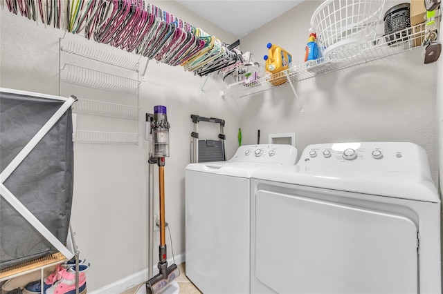 laundry area featuring laundry area, washing machine and dryer, and baseboards