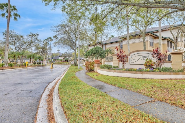 view of road with sidewalks, curbs, a residential view, and a gated entry