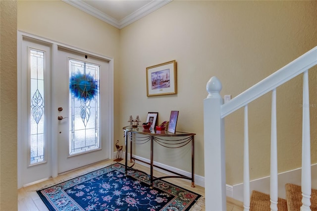 foyer featuring stairway, wood finished floors, and crown molding